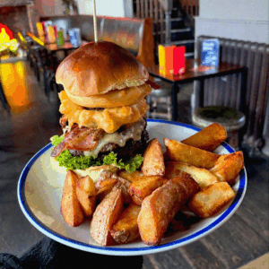 Food offers. Stacked beef burger with melted cheese and fresh toppings, featured as part of a True North food offer.
