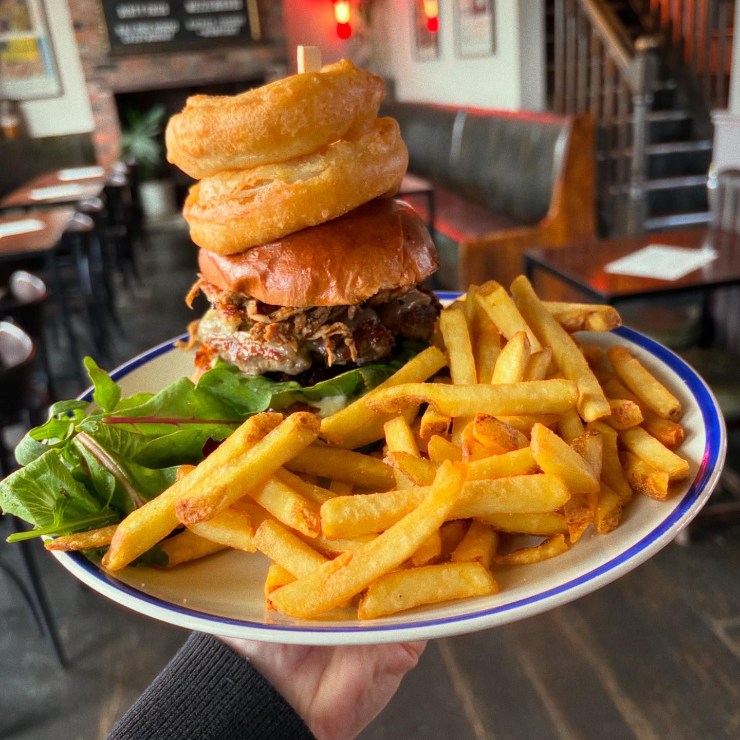 The Riverside Kelham stacked burger with onion rings and chips